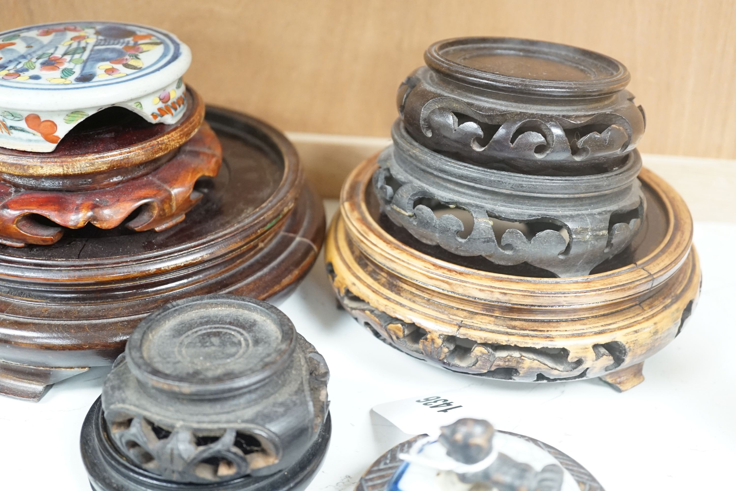 A group of Chinese wooden stands and three ceramics covers.